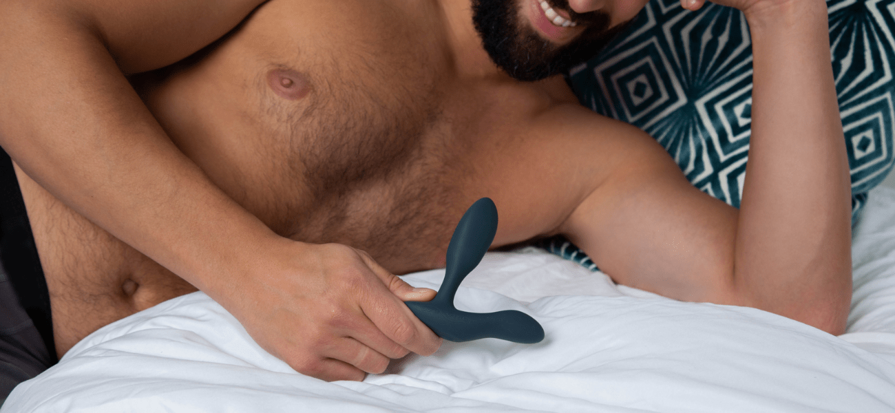 Un jeune homme qui tient un sextoy de plaisir masculin dans sa main